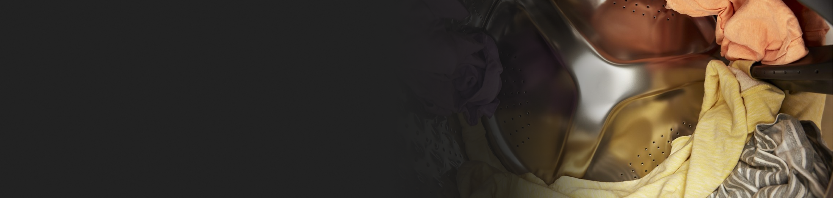 Brightly colored clothing spinning in a dryer.