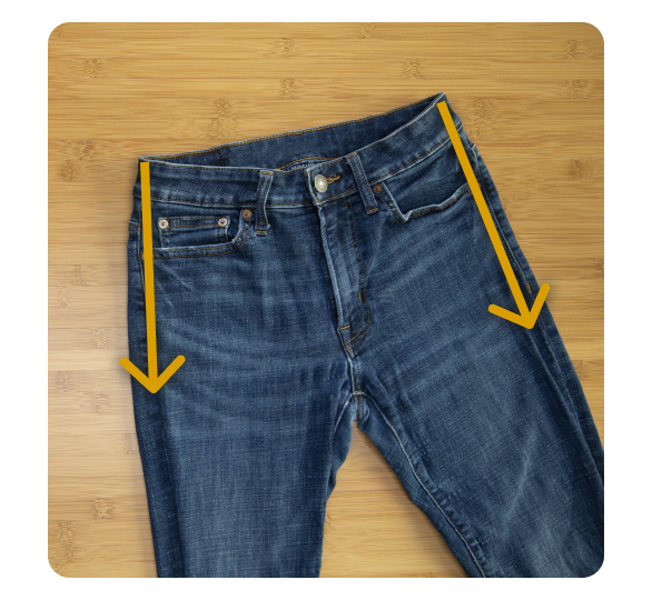 A flat pair of jeans with arrows pointing down A flat pair of jeans with arrows pointing down