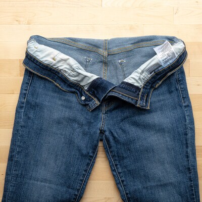 Jeans placed flat on a table with the pockets emptied out