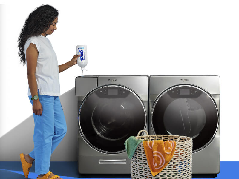 Woman adding Swash® detergent in a front load washing machine Woman adding Swash® detergent in a front load washing machine