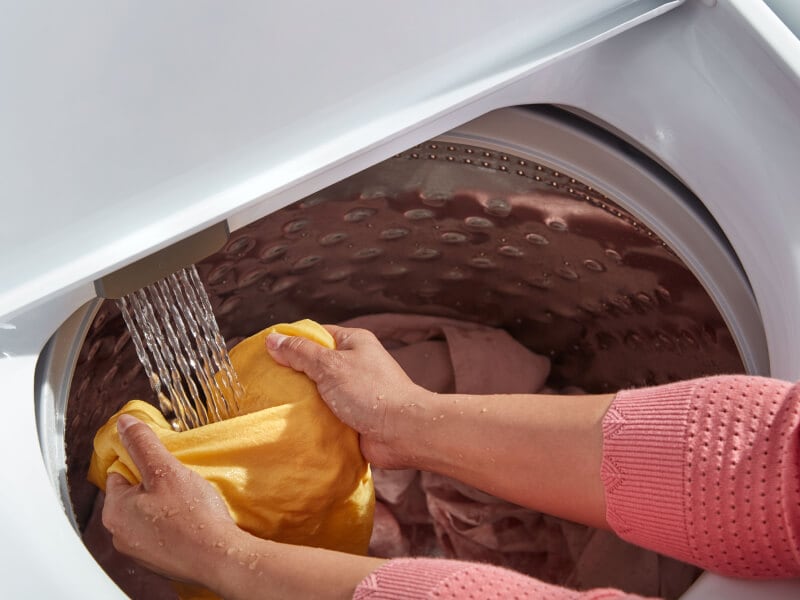 Person rinsing clothes in a Whirlpool® washing machine Person rinsing clothes in a Whirlpool® washing machine