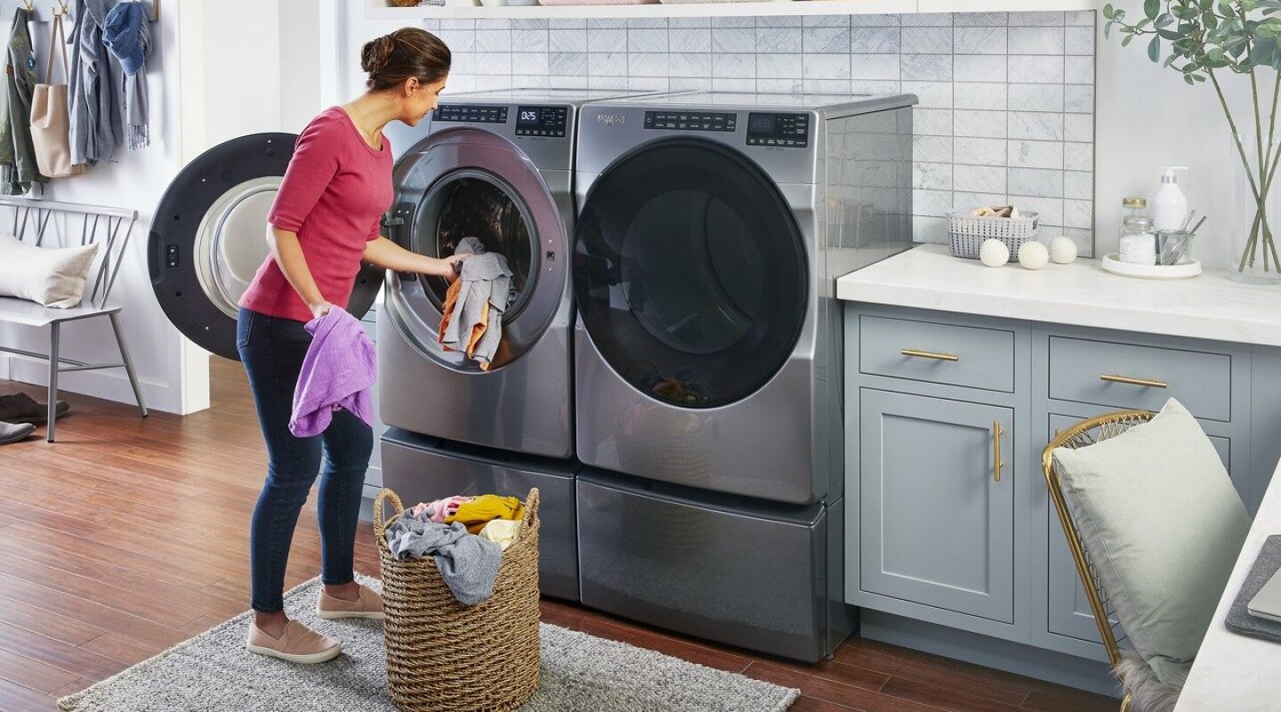 Person loading laundry into a Whirlpool® Front Load Washing Machine