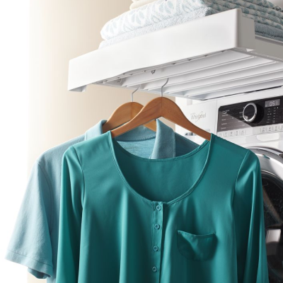 Two blue shirts hanging from hangers