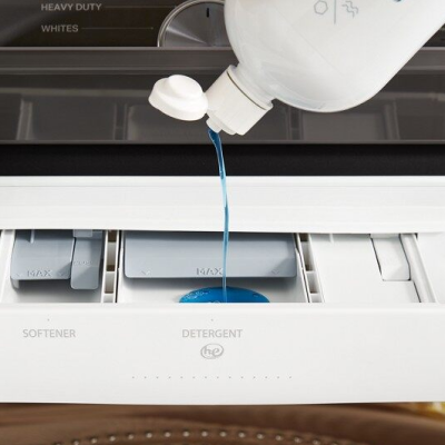 Detergent being added to detergent dispenser