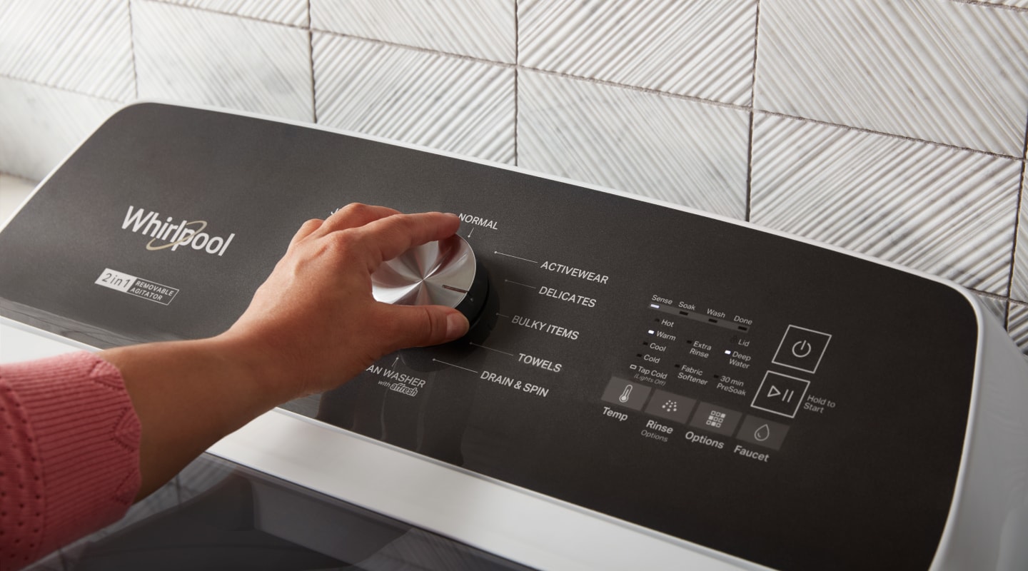 Person selecting a cycle on a Whirlpool® washing machine Person selecting a cycle on a Whirlpool® washing machine