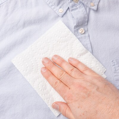 Hand dabbing a shirt with a paper towel