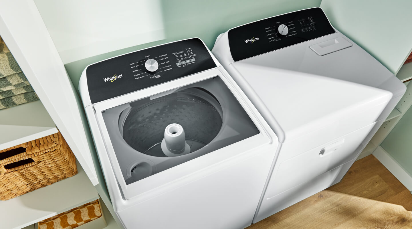 A Whirlpool® Top Load Washer and matching dryer in a laundry room