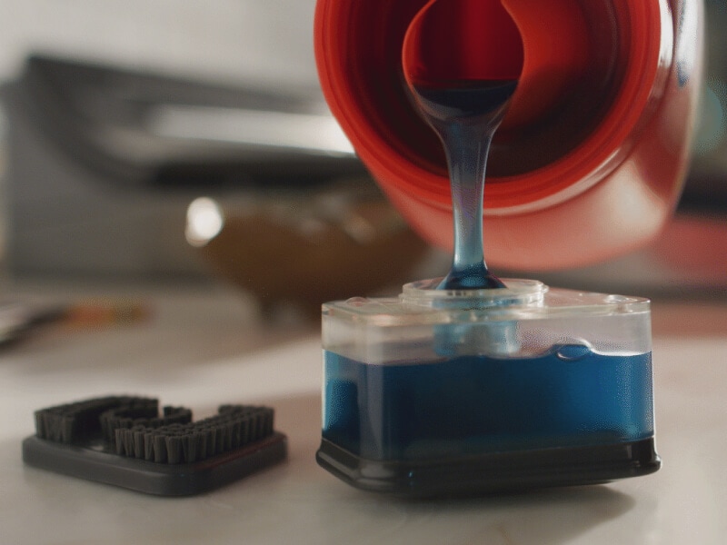 Person filling a stain spot treater with detergent Person filling a stain spot treater with detergent