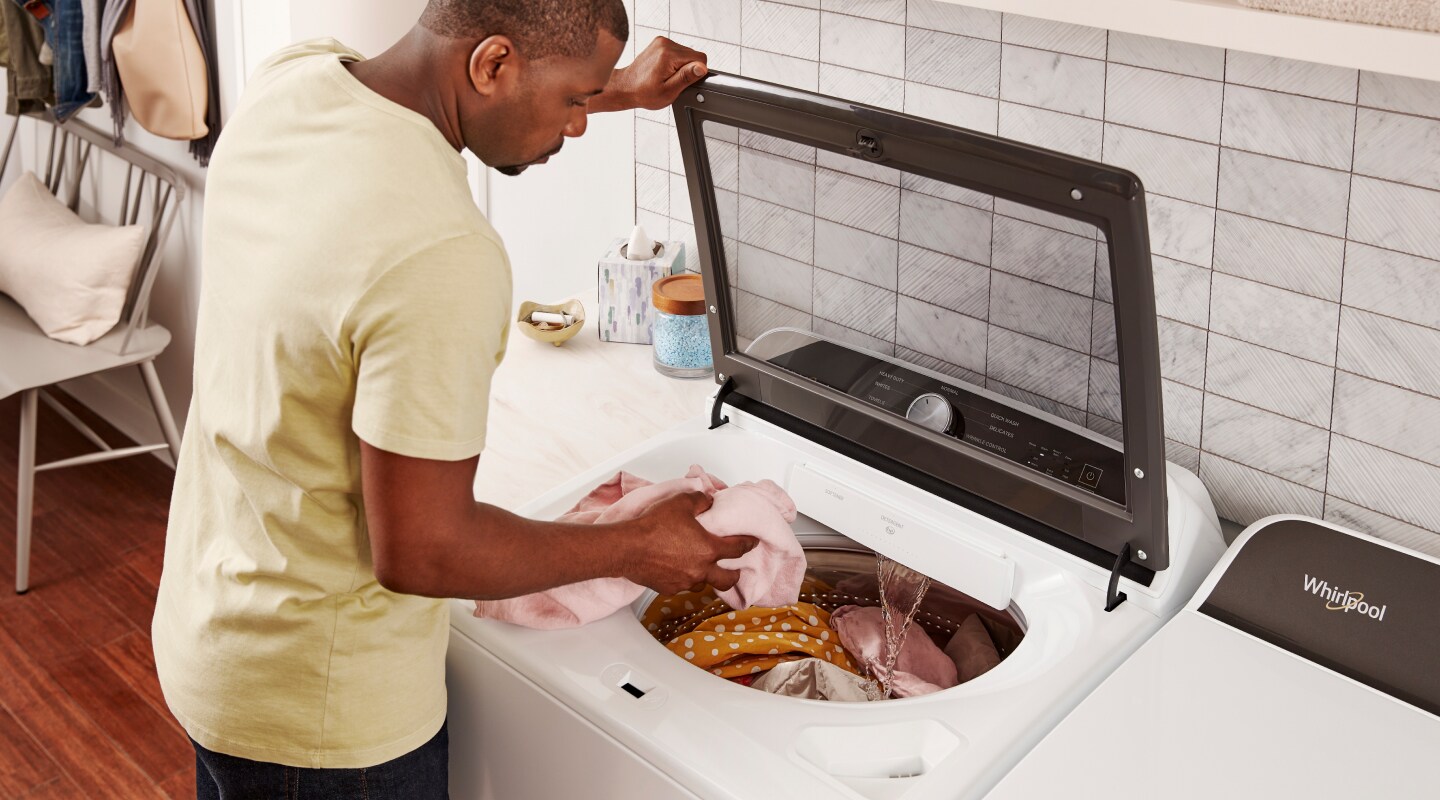Person loading laundry into Whirlpool® washer Person loading laundry into Whirlpool® washer