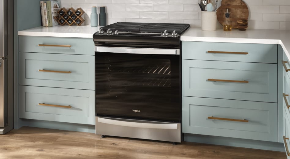 Black gas stove installed between teal cabinets Black gas stove installed between teal cabinets