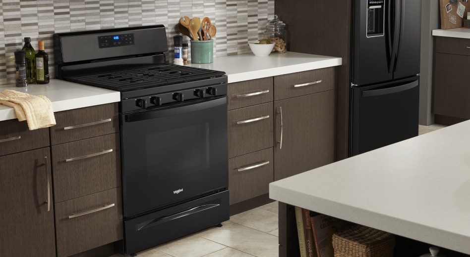 Black Whirlpool® range placed between brown cabinets Black Whirlpool® range placed between brown cabinets