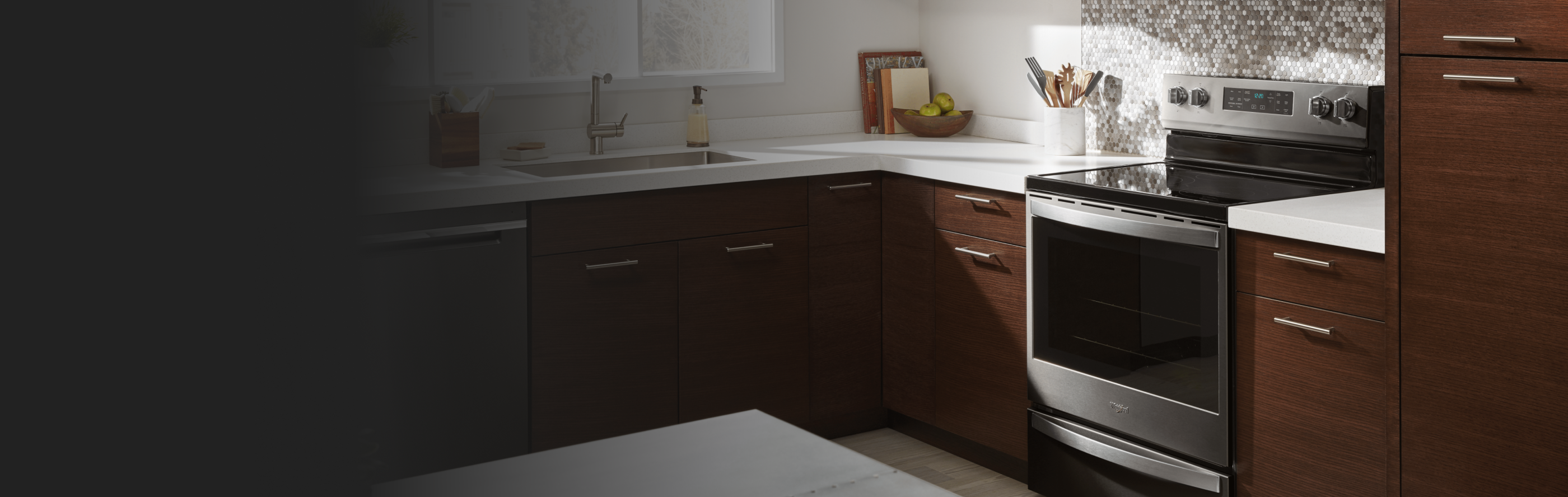 Silver and black electric stove surrounded by brown cabinetry