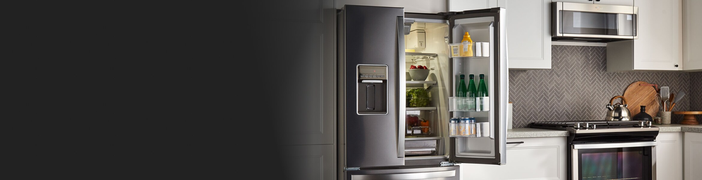 An open French Door refrigerator in a kitchen with white cabinets
