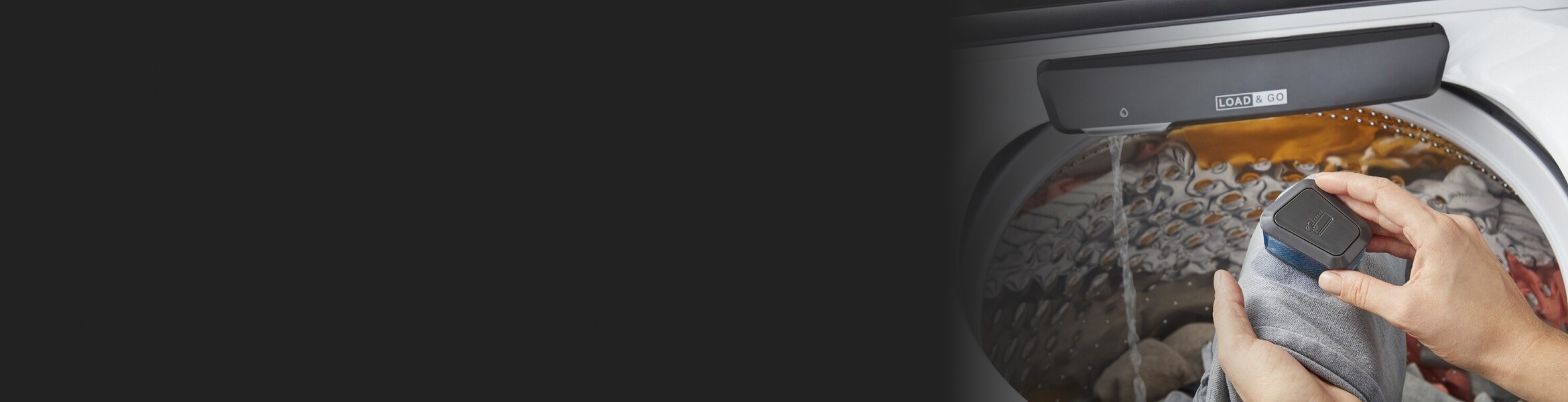 Person scrubbing a garment over a Whirlpool® Top Load Washing Machine with Built-In Faucet.