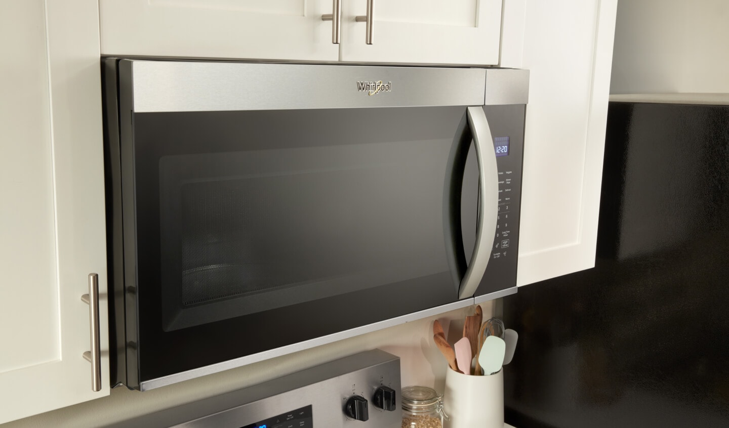 A Whirlpool® Over the Range Microwave that's built into white cabinetry