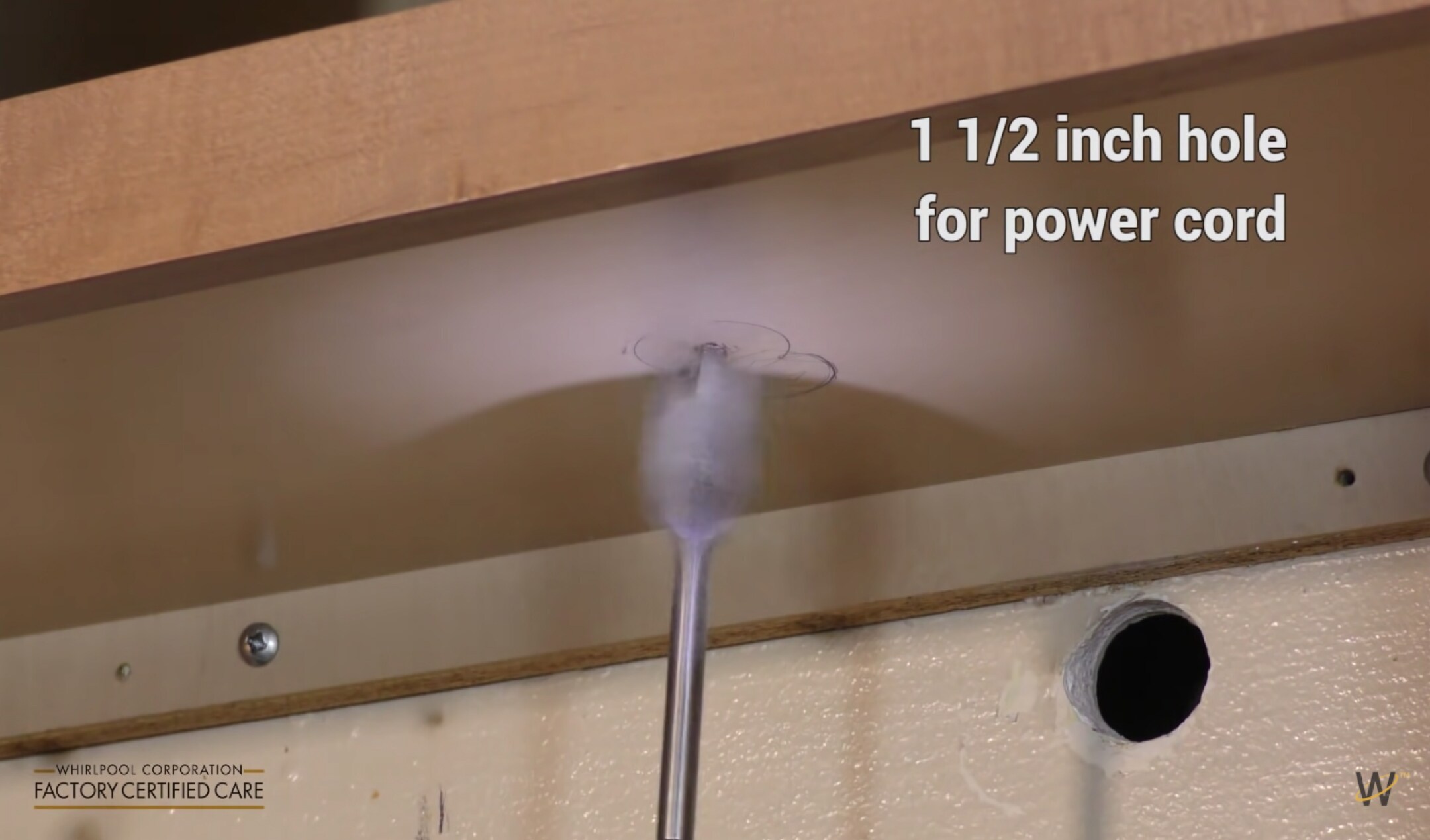 Hole being drilled into the upper cabinet for the microwave power cord
