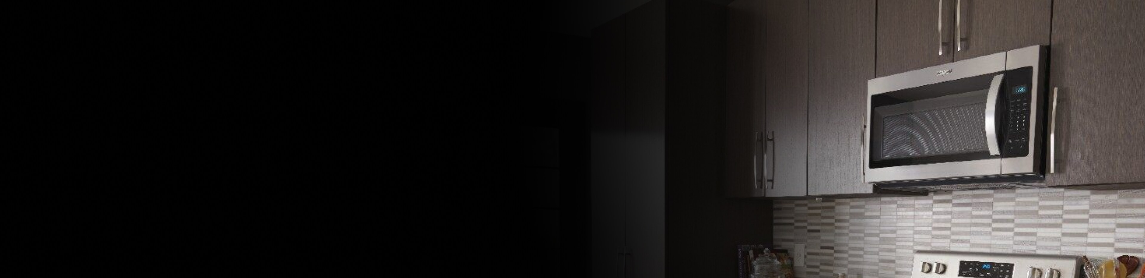 Over-the-range microwave installed and surrounded by brown cabinetry