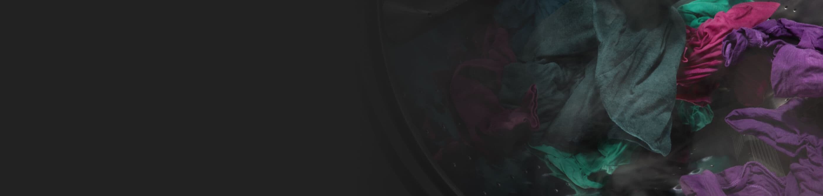 Dark purple and green clothes spinning in a washer