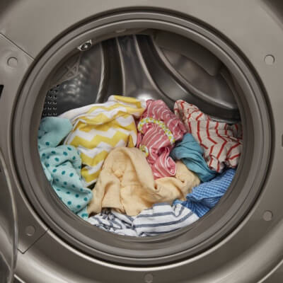 Front load washer opened with colorful clothes inside