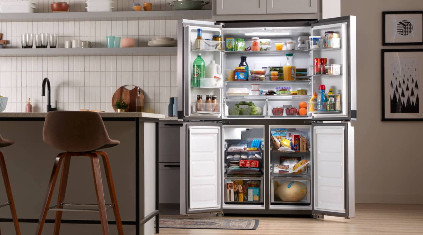 Open four door refrigerator filled with food