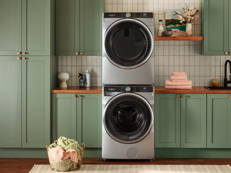 Stacked washer and dryer set in green cabinets Stacked washer and dryer set in green cabinets
