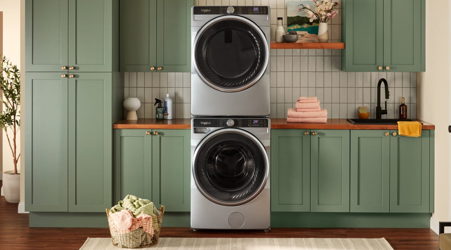 Stacked washer and dryer set in green cabinets Stacked washer and dryer set in green cabinets