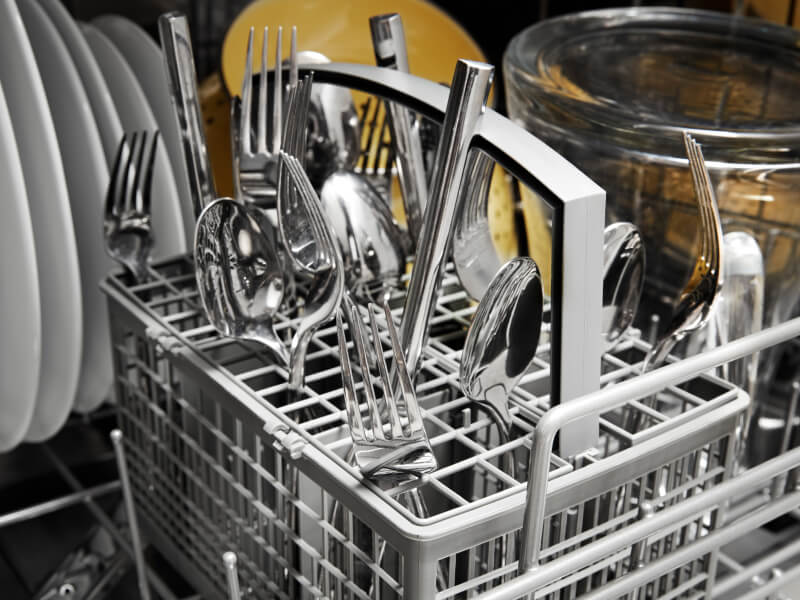 A closeup image of silverware loaded in a silverware basket