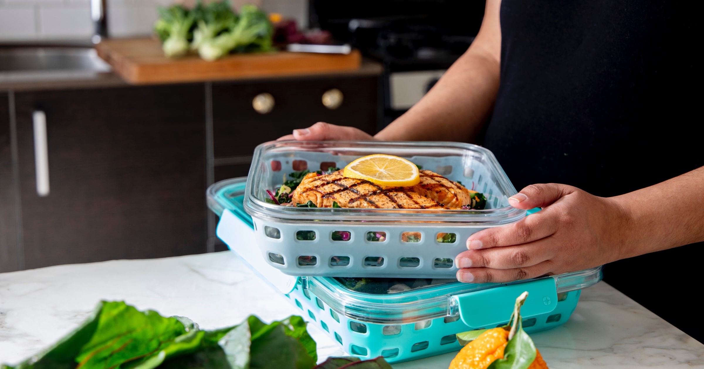 A container with a grilled chicken breast and slice of lemon. A container with a grilled chicken breast and slice of lemon.