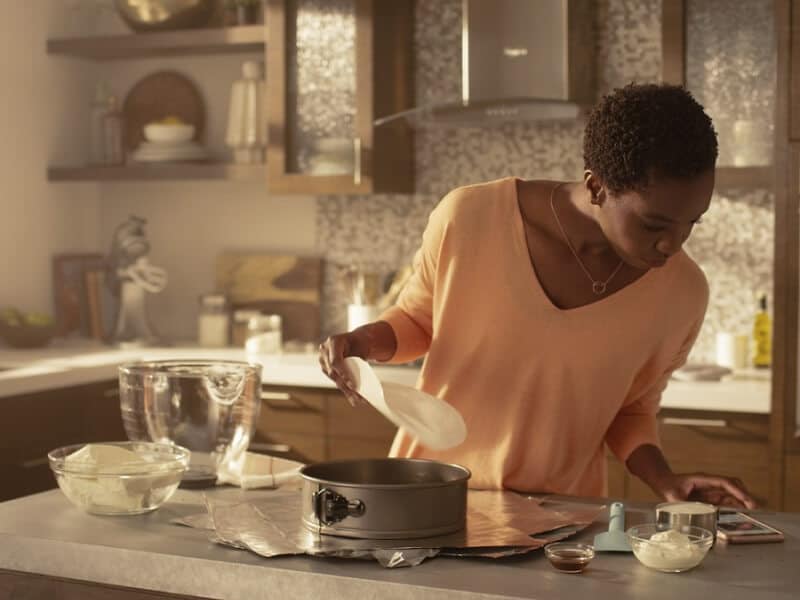 Woman in kitchen reading recipe on her phone 