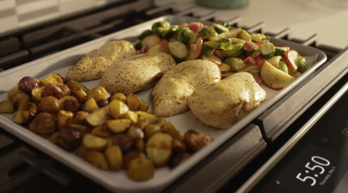 Close up of a sheet pan with chicken breasts and vegetables 