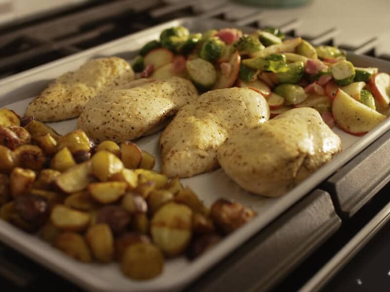 Close up of a sheet pan with chicken breasts and vegetables 