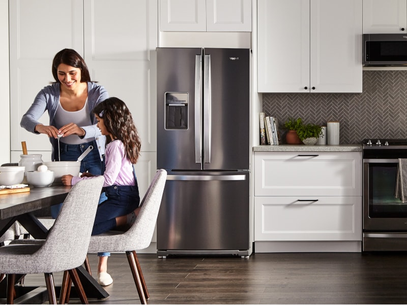 Mother and daughter cooking at the dining table in a large kitchen Mother and daughter cooking at the dining table in a large kitchen
