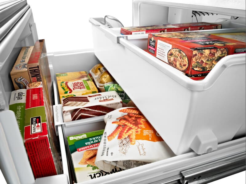 Bottom freezer drawer opened showing organized freezer bins