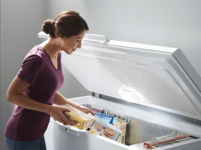 Person taking food out of an open chest freezer