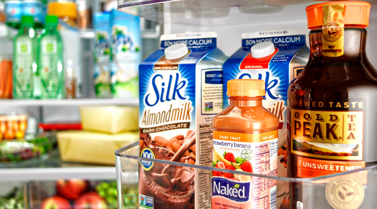 Various beverages stored in a fridge door bin Various beverages stored in a fridge door bin