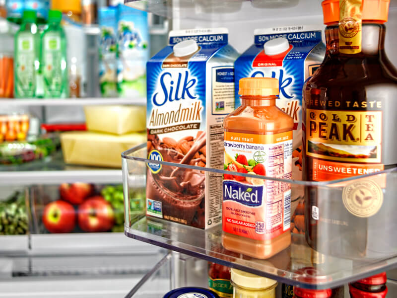 Various beverages stored in a fridge door bin Various beverages stored in a fridge door bin