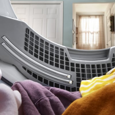 Laundry resting in the drum of an opened dryer.