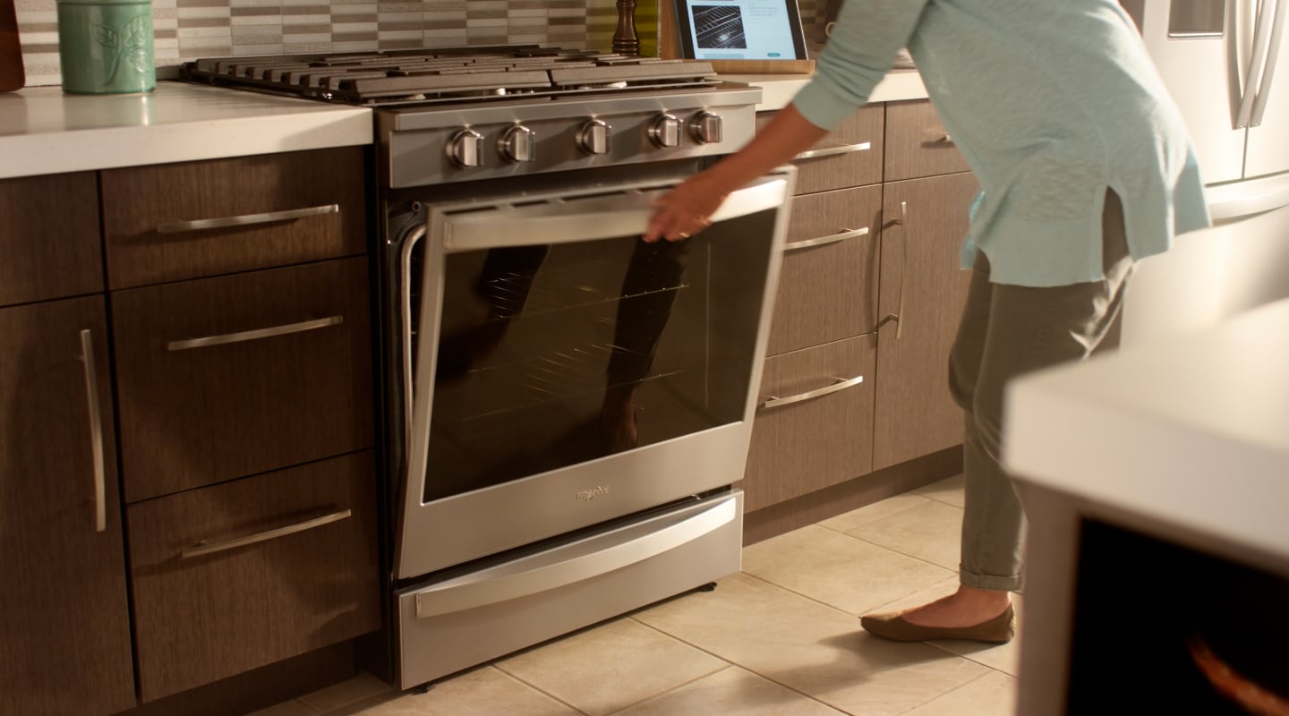 Person opening the door of an oven