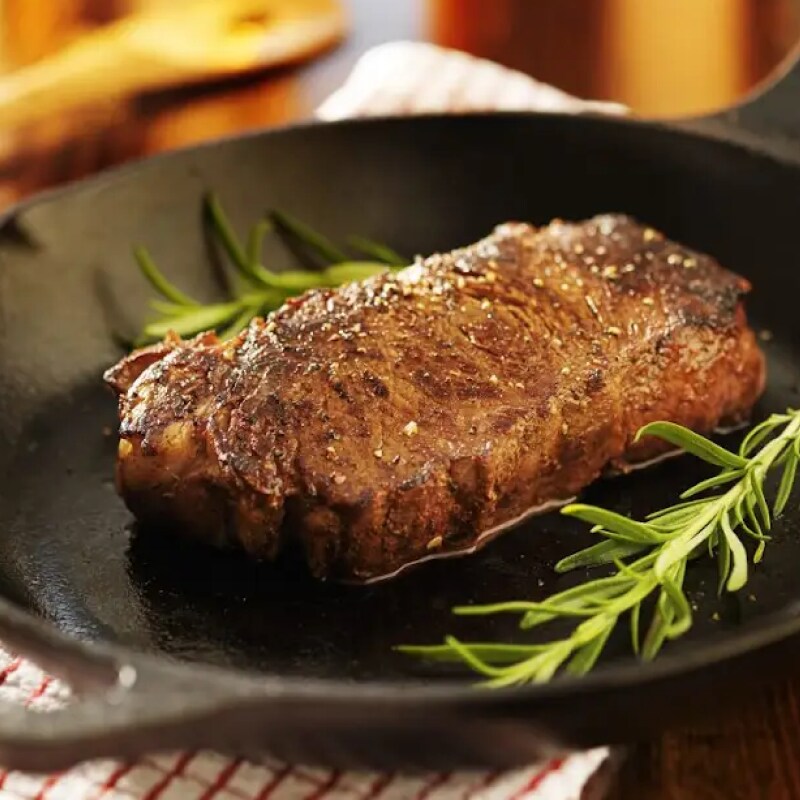Pan seared steak in a cast iron skillet with garnish