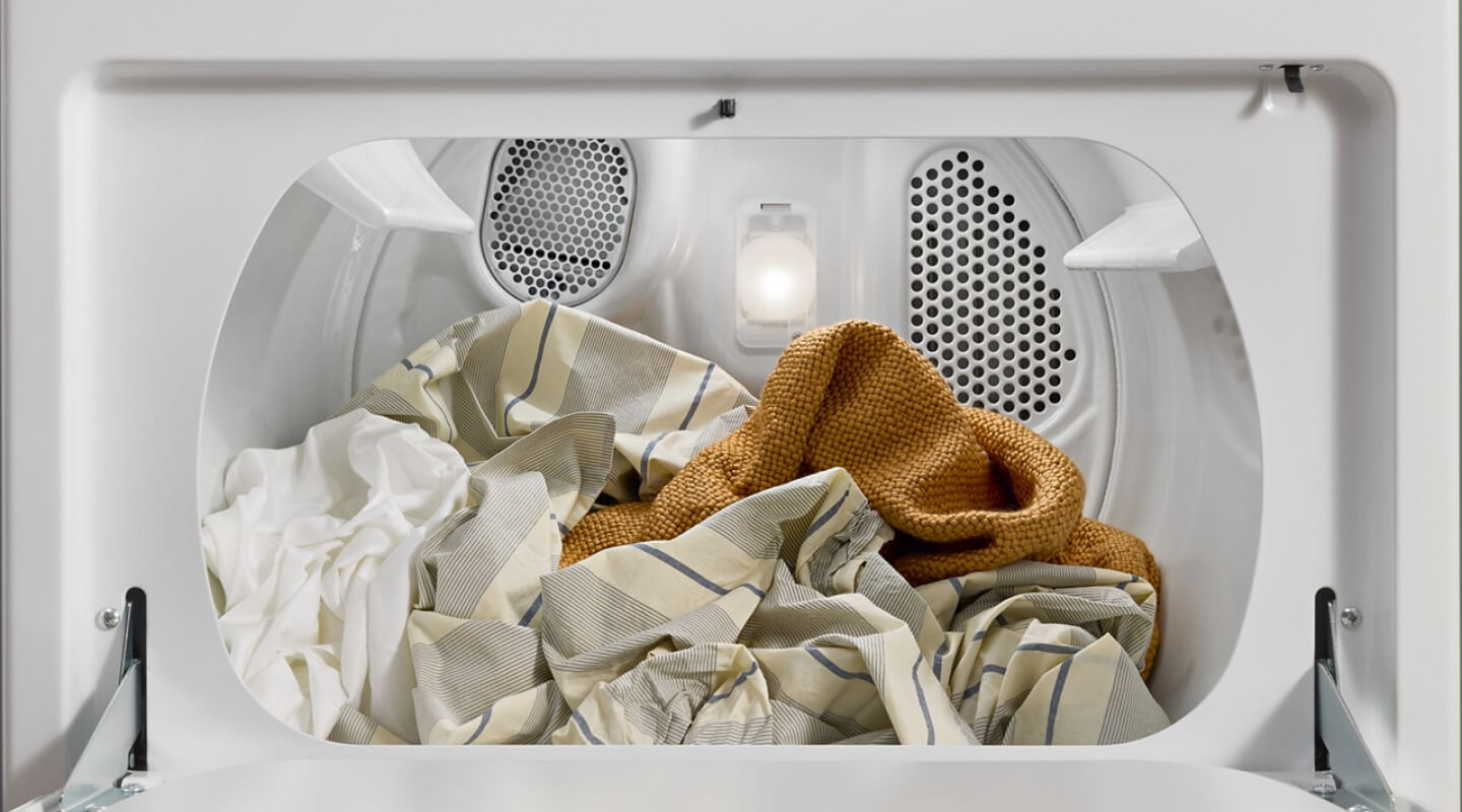 An open dryer with laundry inside An open dryer with laundry inside