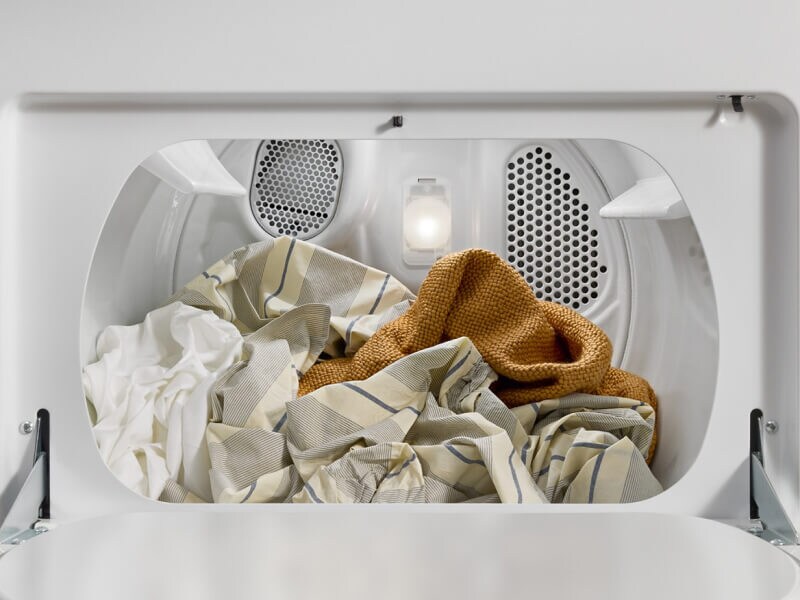 An open dryer with laundry inside An open dryer with laundry inside