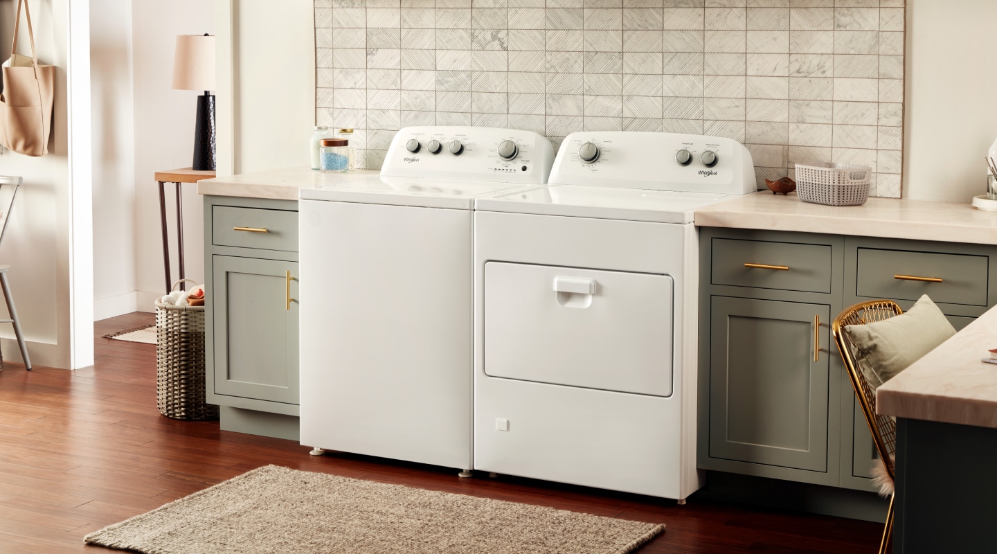 White Whirlpool® washer and dryer pair in gray-brown cabinetry White Whirlpool® washer and dryer pair in gray-brown cabinetry
