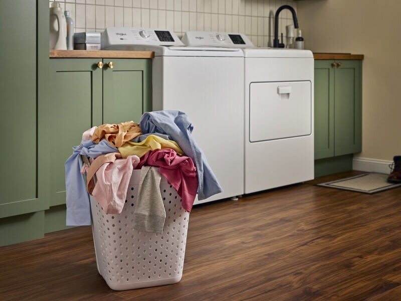 Clothes in a basket in front of a white Whirlpool® Washer and Dryer Clothes in a basket in front of a white Whirlpool® Washer and Dryer