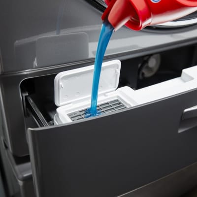 Detergent being poured into a dispenser