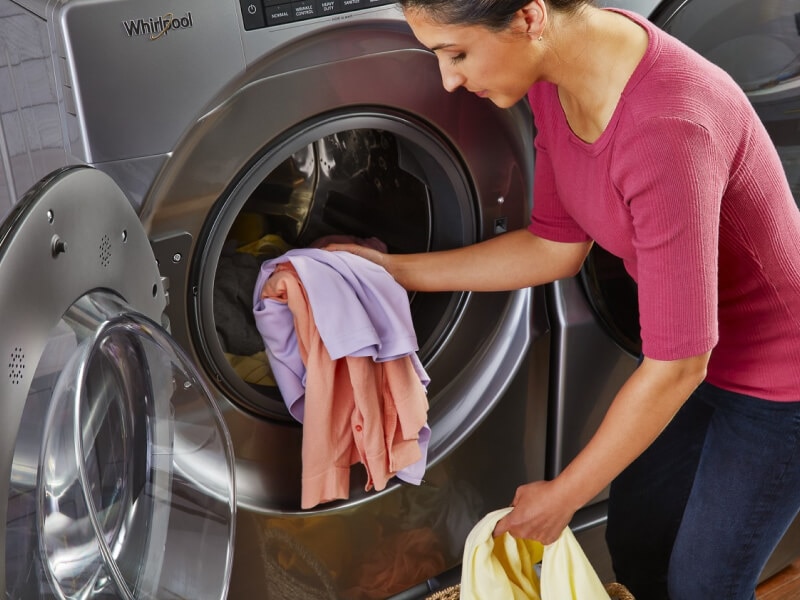 A person loading a washer A person loading a washer