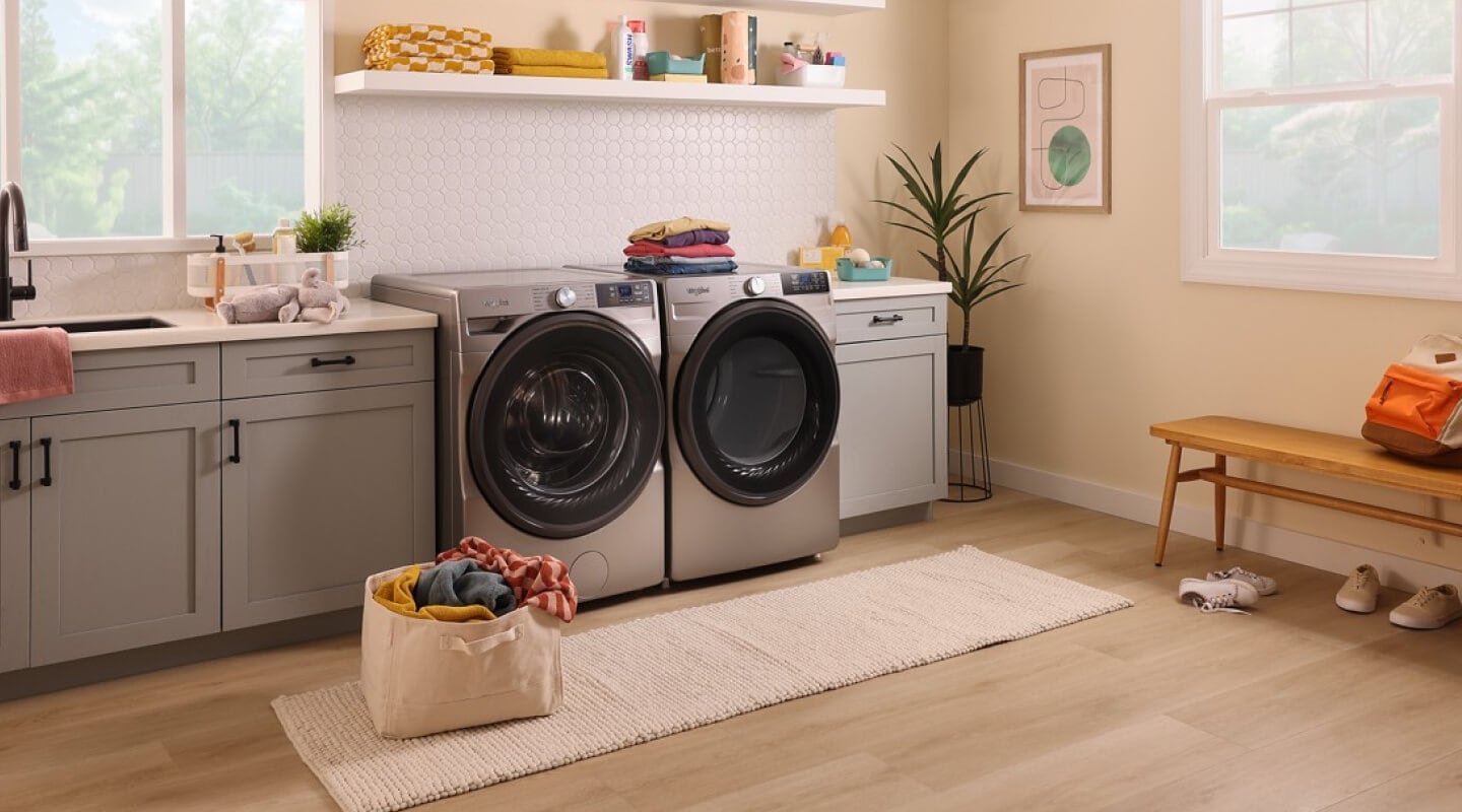 A bright laundry room with a bag of laundry on the floor in front of a Whirlpool® Washer and Dryer set A bright laundry room with a bag of laundry on the floor in front of a Whirlpool® Washer and Dryer set