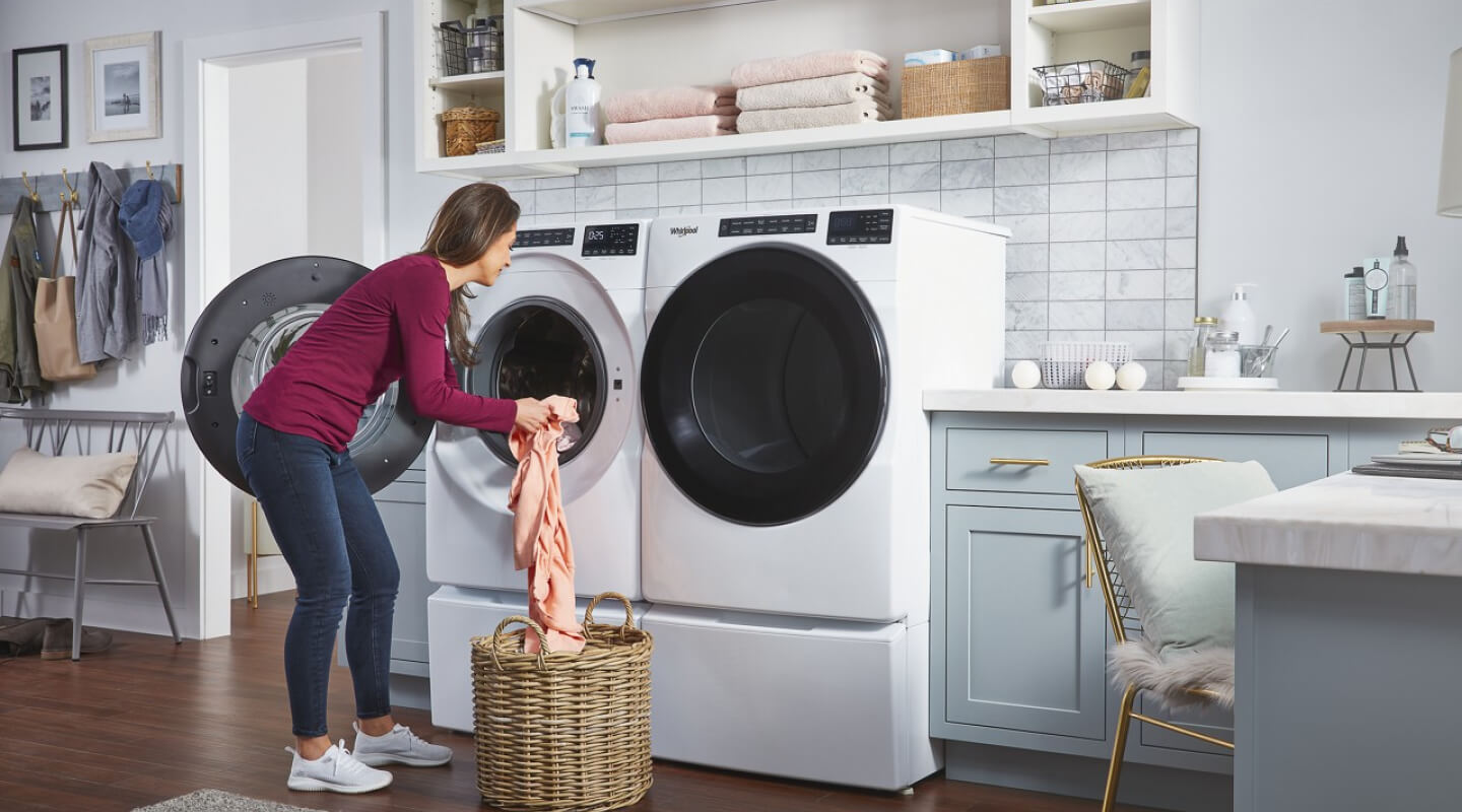 A woman loading clothes into a Whirlpool® Washer A woman loading clothes into a Whirlpool® Washer
