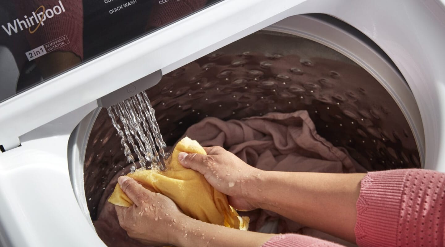 A person using the Built-In Water Faucet in their Whirlpool® Washer with 2 in 1 Removable Agitator A person using the Built-In Water Faucet in their Whirlpool® Washer with 2 in 1 Removable Agitator
