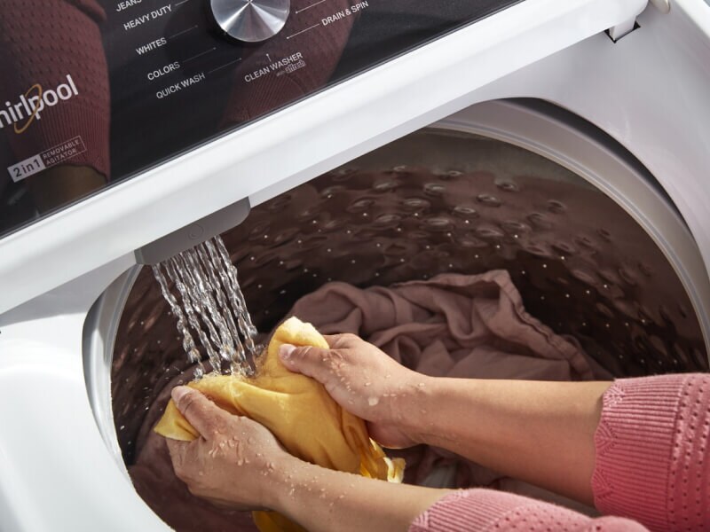 A person using the Built-In Water Faucet in their Whirlpool® Washer with 2 in 1 Removable Agitator A person using the Built-In Water Faucet in their Whirlpool® Washer with 2 in 1 Removable Agitator