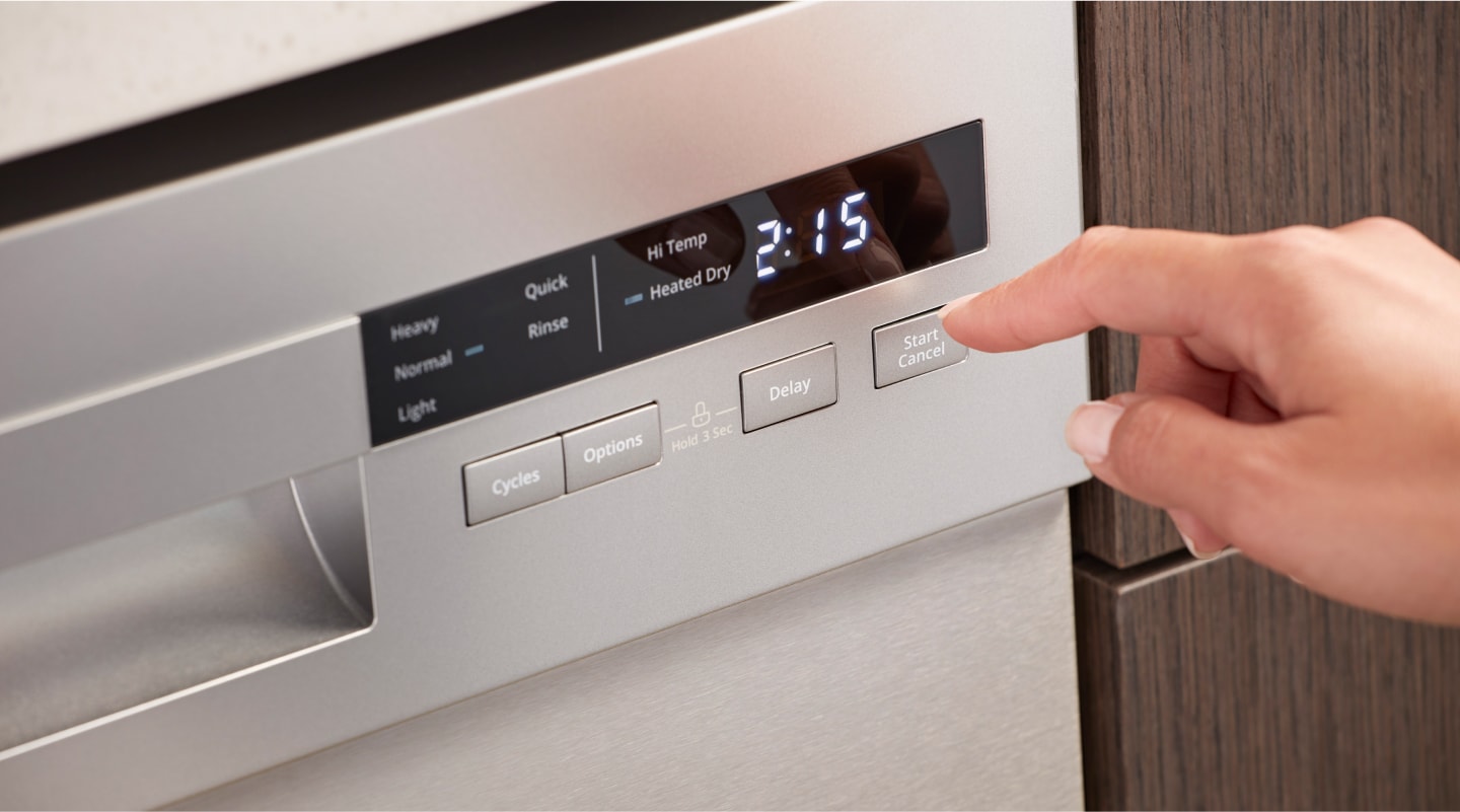 Person selecting wash cycle options on dishwasher control panel Person selecting wash cycle options on dishwasher control panel